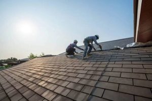 Professional roofing contractors replacing an asphalt shingle roof during ideal weather conditions in Port Angeles, Washington.
