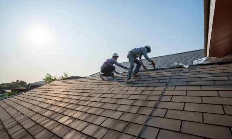 Professional roofing contractors replacing an asphalt shingle roof during ideal weather conditions in Port Angeles, Washington.