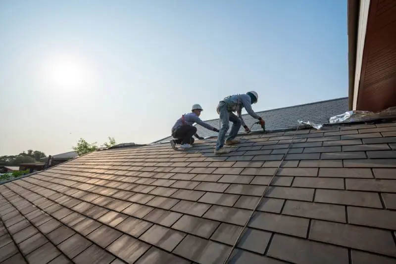 Professional roofing contractors replacing an asphalt shingle roof during ideal weather conditions in Port Angeles, Washington.